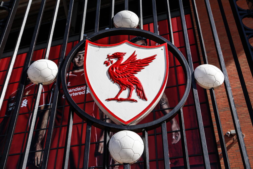 A photo of the badge of the liver bird in a metal red and white circle on a gate outside the Anfield Stadium home of Premier League team Liverpool Football Club